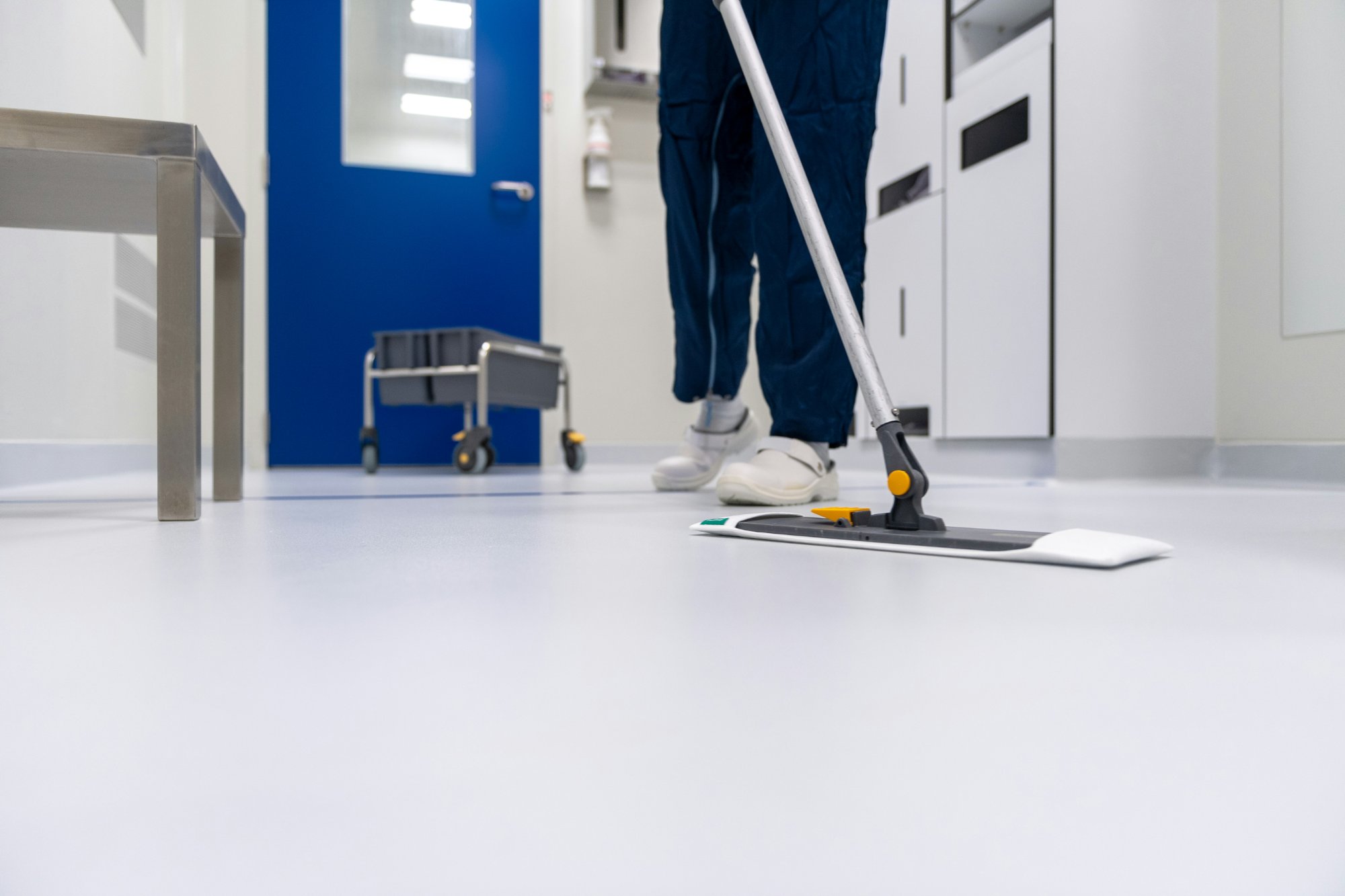 Professional floor cleaning with commercial-grade mop in a facility hallway